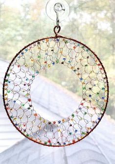 a circular glass hanging decoration on a window sill