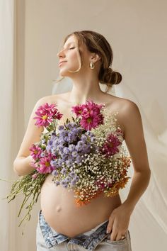 a pregnant woman holding flowers in her belly