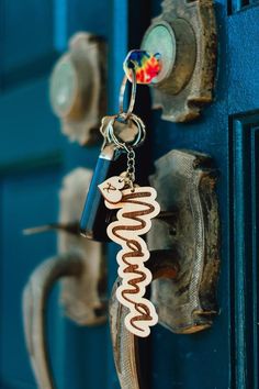 a close up of a key chain attached to a door with the word coco on it