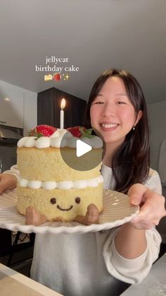 a woman holding a cake with candles on it