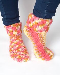 the legs of a woman wearing pink and yellow knitted socks