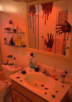 a bathroom decorated for halloween with hand prints on the mirror