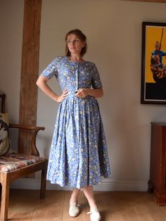 A lovely vintage cotton sun dress, made by Laura Ashley in the late 1980s.  Buttons all the way from the top and bottom. Made from soft light cotton, with a yellow and blue floral print. Pleats to the skirt.  The dress is unfortunately missing the size / fabric contents label, but I've sold identical dresses to this one before and it is definitely 100% cotton. Very good vintage condition apart from the missing label. Chest: 32"/82 cm Waist: 37"/ 94cm Length: 47"/ 120cm Cotton A-line Vintage Dress, Cotton Vintage Print Dress For Daywear, Cotton Vintage Dress With Vintage Print For Daywear, Spring Cotton Fitted Prairie Dress, Fitted Vintage Cotton Prairie Dress, Spring Cotton Prairie Dress For Daywear, Vintage Cotton Dress For Garden Party, Blue Prairie Dress For Summer, Cotton Vintage Dress For Garden Party