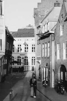 an old black and white photo of a person walking down the street in front of some buildings