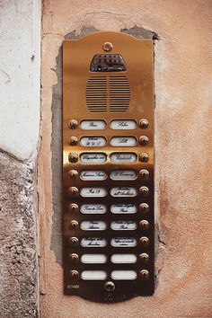 an old cell phone is mounted to the side of a building with holes in it