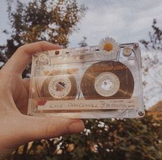 a person holding up a clear plastic case with two cds in it