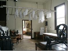 an old fashioned room with many items hanging from the ceiling