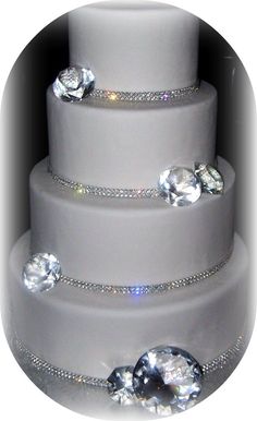 a three tiered wedding cake with diamonds on it