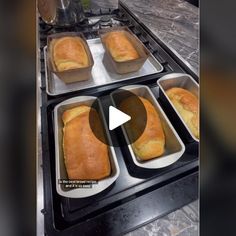 four loafs of bread sitting in pans on top of a stovetop next to an oven