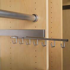 there is a coat rack with hooks on the wall next to some cupboards and shelves