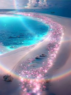 a long line of pink flowers on the beach next to an ocean with blue water