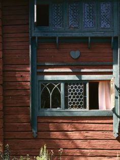 an open window on the side of a red building