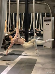 some people are doing yoga in the middle of an indoor area with white and black mats