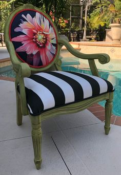 a chair with a flower painted on it next to a pool