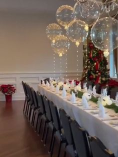 a long table is set up for a christmas party with balloons in the shape of balls