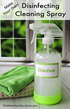 a bottle of disinfecting cleaning spray next to a green towel