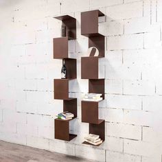 a bookshelf that is on the wall in front of a white brick wall