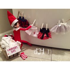 an elf is hanging laundry day clothes on a line next to a bathtub and socks