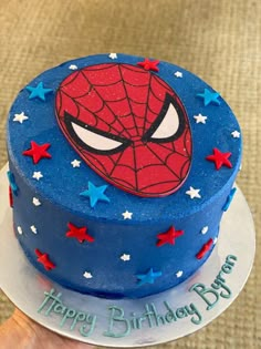 a spiderman birthday cake with blue frosting and stars