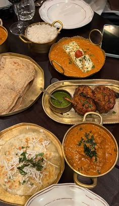 a table topped with lots of different types of food on plates and serving trays