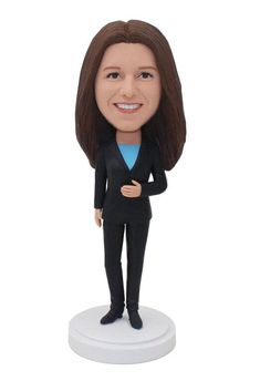 a custom bobble head girl in a suit and blue shirt standing on a white base