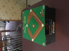 a cardboard box with a baseball game on it sitting on a table in a living room