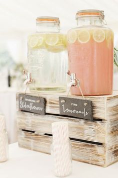 two mason jars filled with lemonade sitting on top of a wooden crate next to each other