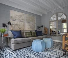 a living room filled with furniture and lots of blue pillows on top of a rug