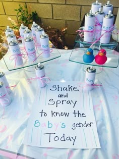 a table topped with lots of baby's genderal candles and bottles filled with water