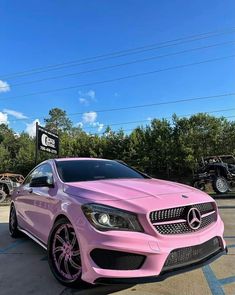 a pink mercedes cla parked in a parking lot