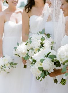 the bride and her bridesmaids are all dressed in white dresses with bouquets