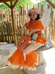 a woman in an orange costume sitting on a bench