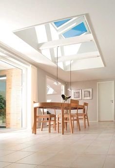 a dining room table and chairs under a skylight in an open floor plan with sliding glass doors