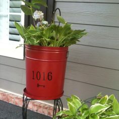 a potted plant sitting on top of a metal stand next to a house door