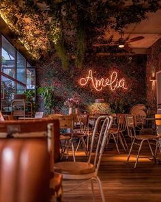 the inside of an empty restaurant with tables and chairs in front of large windows that read, amela