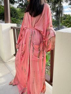 Lightweight and breathable with its gorgeous oversized length, the Swan - Peach Pink Kimono Robe is a must-have with its vibrant color. This relaxed design features a gorgeous tie-dye print paired with a chic waist tie. side pockets and elegant side slits. Layer it on over your favorite outfit for an effortless pop of color. Features: Lightweight feel Very comfortable and breathable Tie-dye Handmade Oversized fit Long sleeves Removable waist tie closure Two pockets Side slits at the hem Size + F Elegant Boho Outfit, Oversized Kimono, Tie Dye Kimono, Bridesmaid Kimono, Kaftan Designs, Pink Kimono, Kimono Outfit, Mode Kimono, Boho Dresses Long