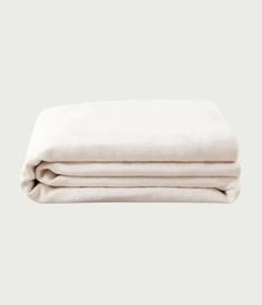 the linen sheets are folded on top of each other, with one sheet pulled back