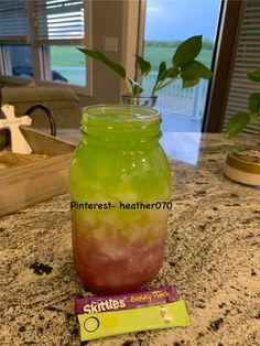 a green and red drink sitting on top of a counter next to a candy bar