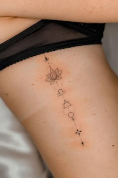 a woman's lower back tattoo with the word spa on it and a flower