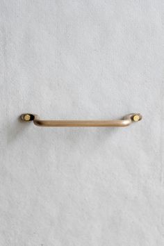 a gold handle on a white wall