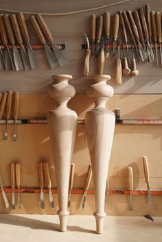 two wooden vases sitting on top of a table next to knives and spoons