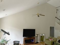 a living room filled with furniture and a flat screen tv on top of a hard wood floor