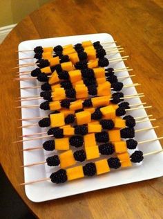 some food is on a white plate and has blackberries and orange for halloween fun