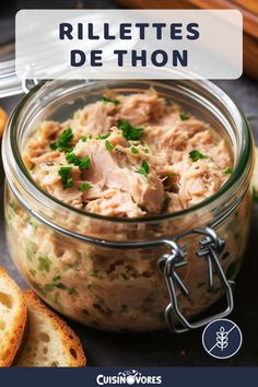 a glass jar filled with food next to bread