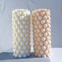 two white vases sitting next to each other on a table