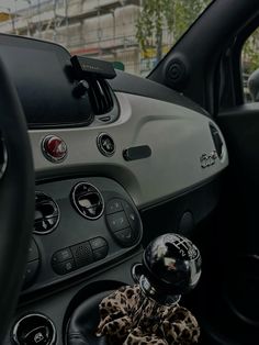 the interior of a car with an animal print steering wheel cover and dashboard knobs