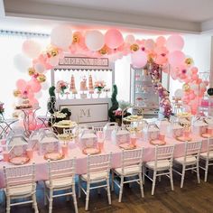 a room filled with tables and chairs covered in balloons