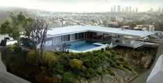 an aerial view of a house with a pool in the foreground and cityscape in the background