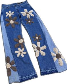 a pair of jeans with flowers painted on the side and one in the back, sitting upright