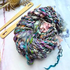 a skein of yarn sitting on top of a table next to some knitting needles